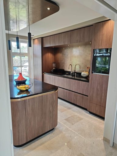 Moderne keuken met houten kasten, zwart aanrecht en kleurige decoratieve vazen.